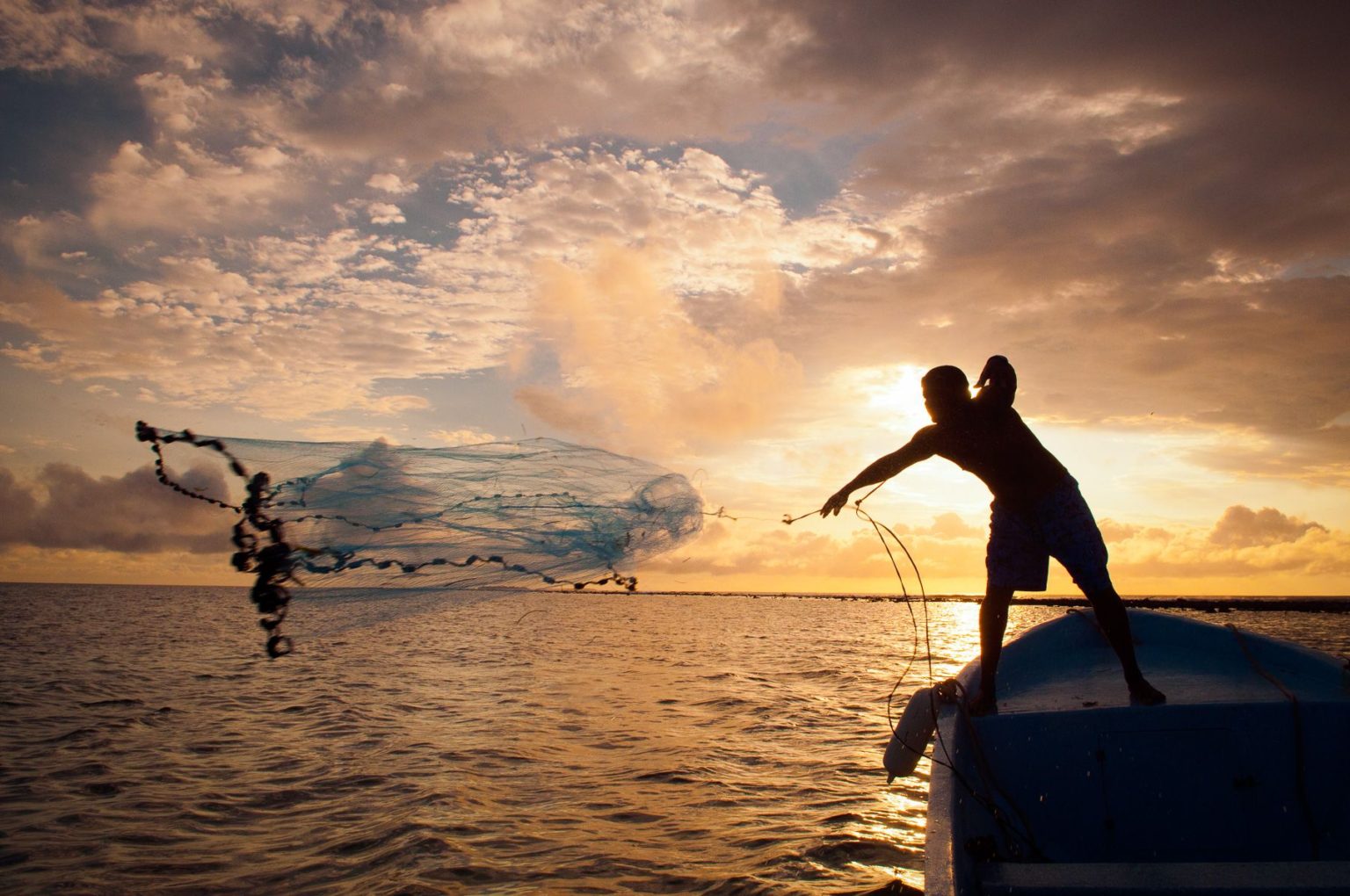 Fisherman casts net at dawn in Belize