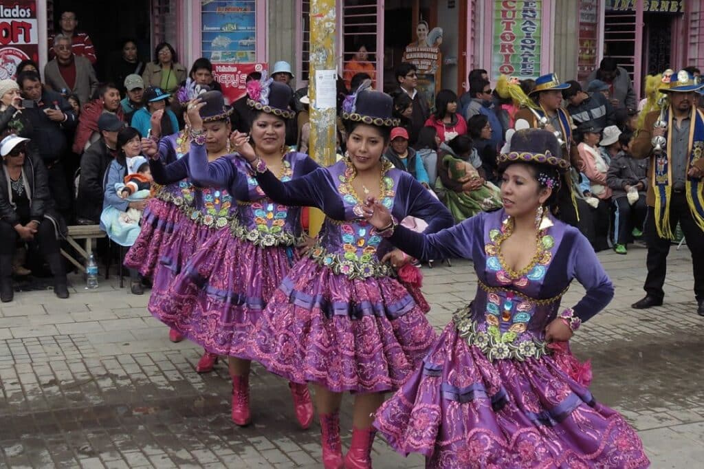 women dancing in colorful dresses on the streets of peru
