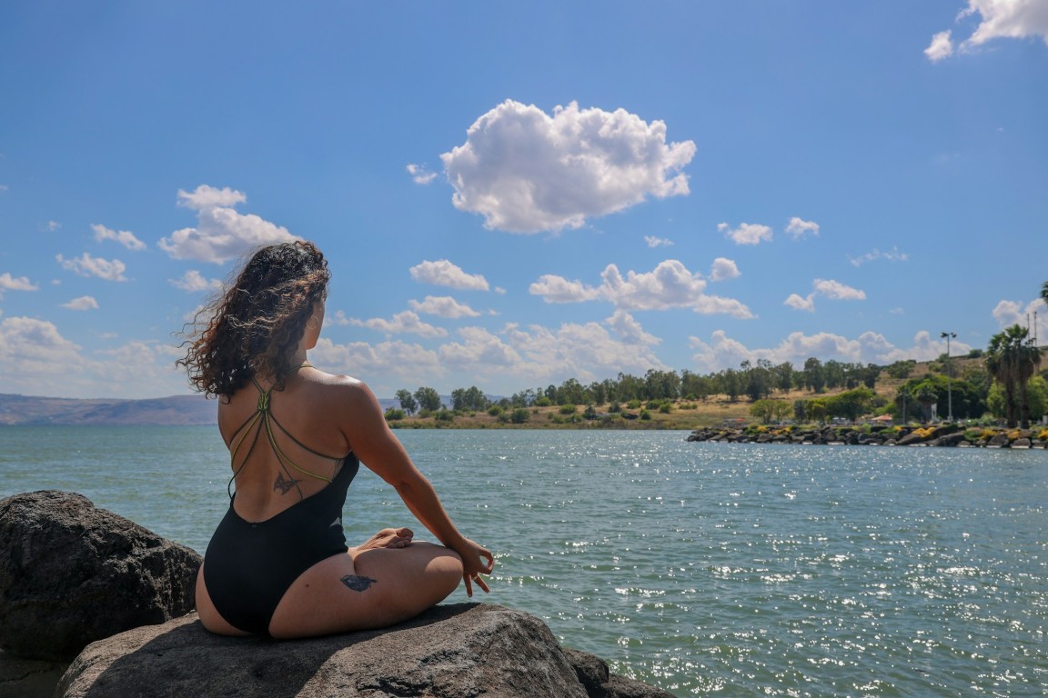 woman sitting beside the sea meditating