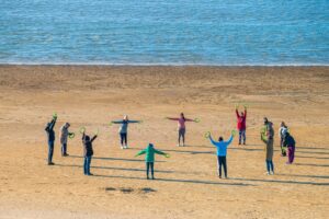 people doing exercises on the beach