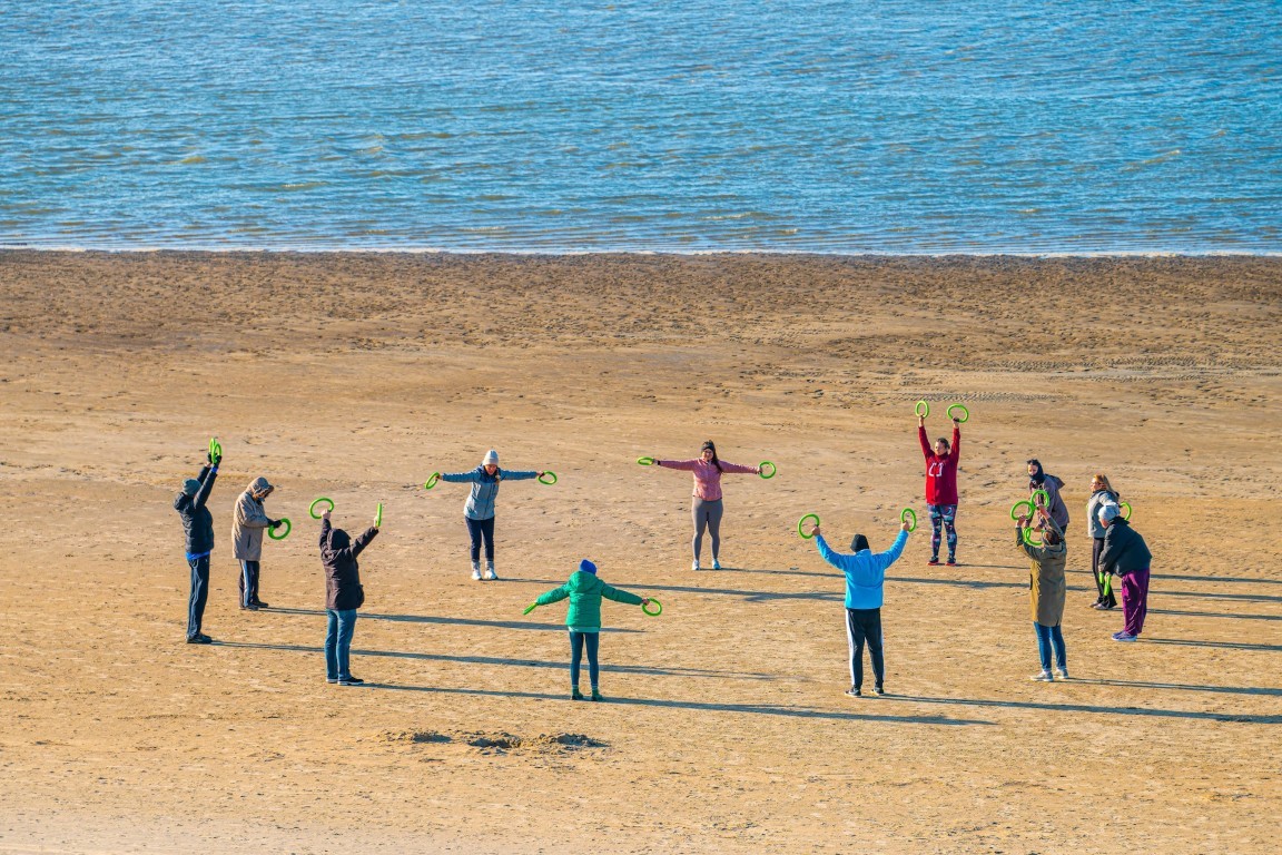 people doing exercises on the beach